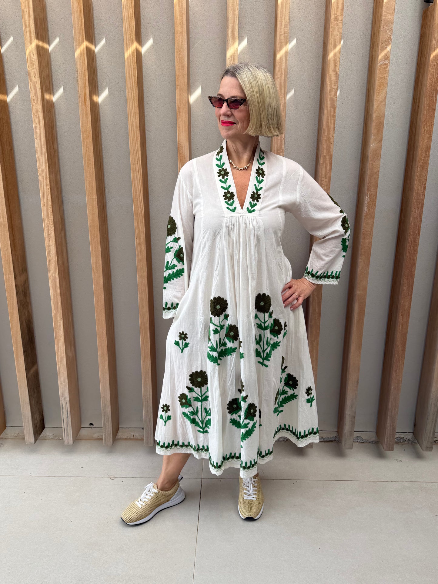 White dress with embroidered green daisies