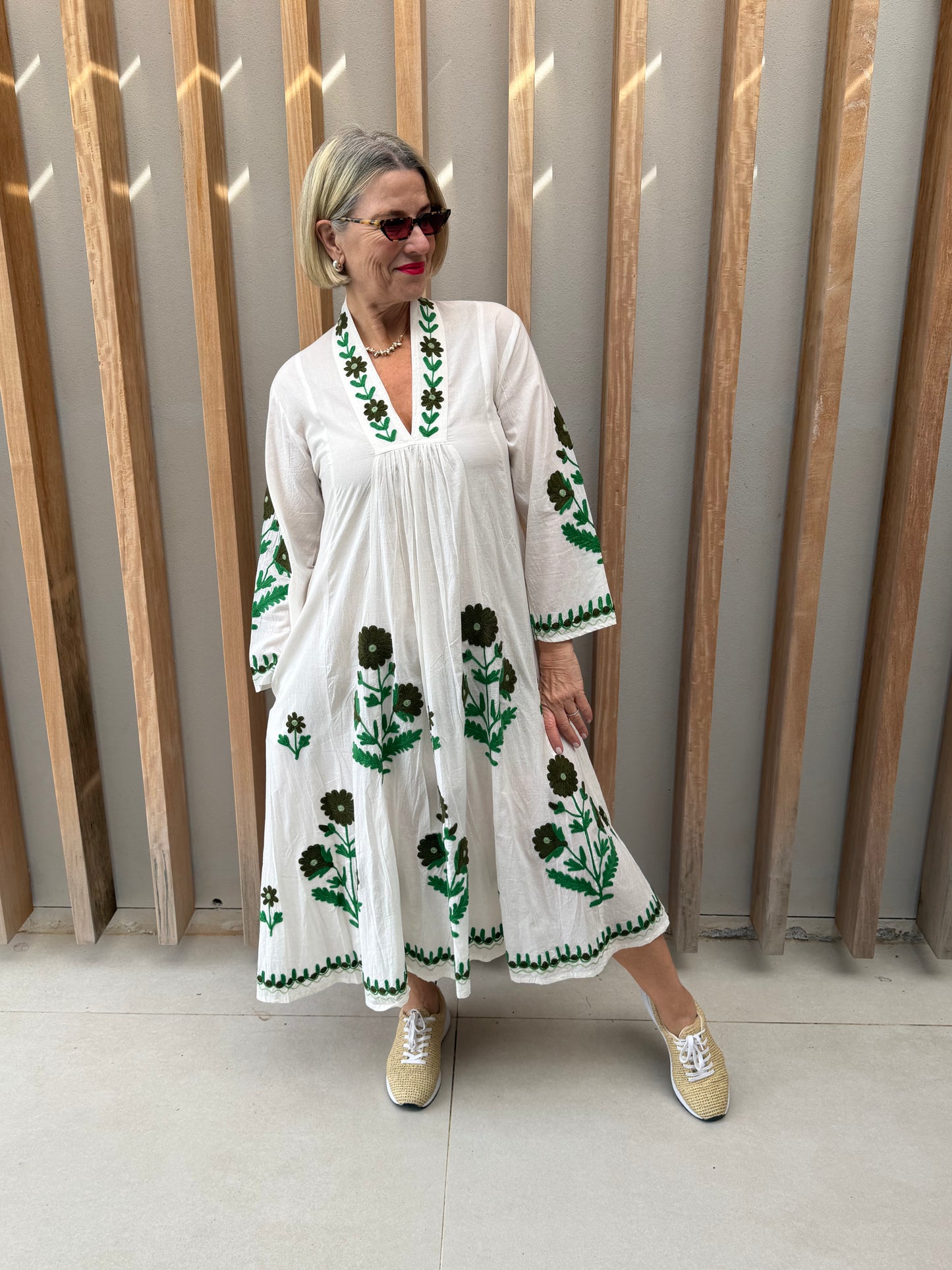 White dress with embroidered green daisies