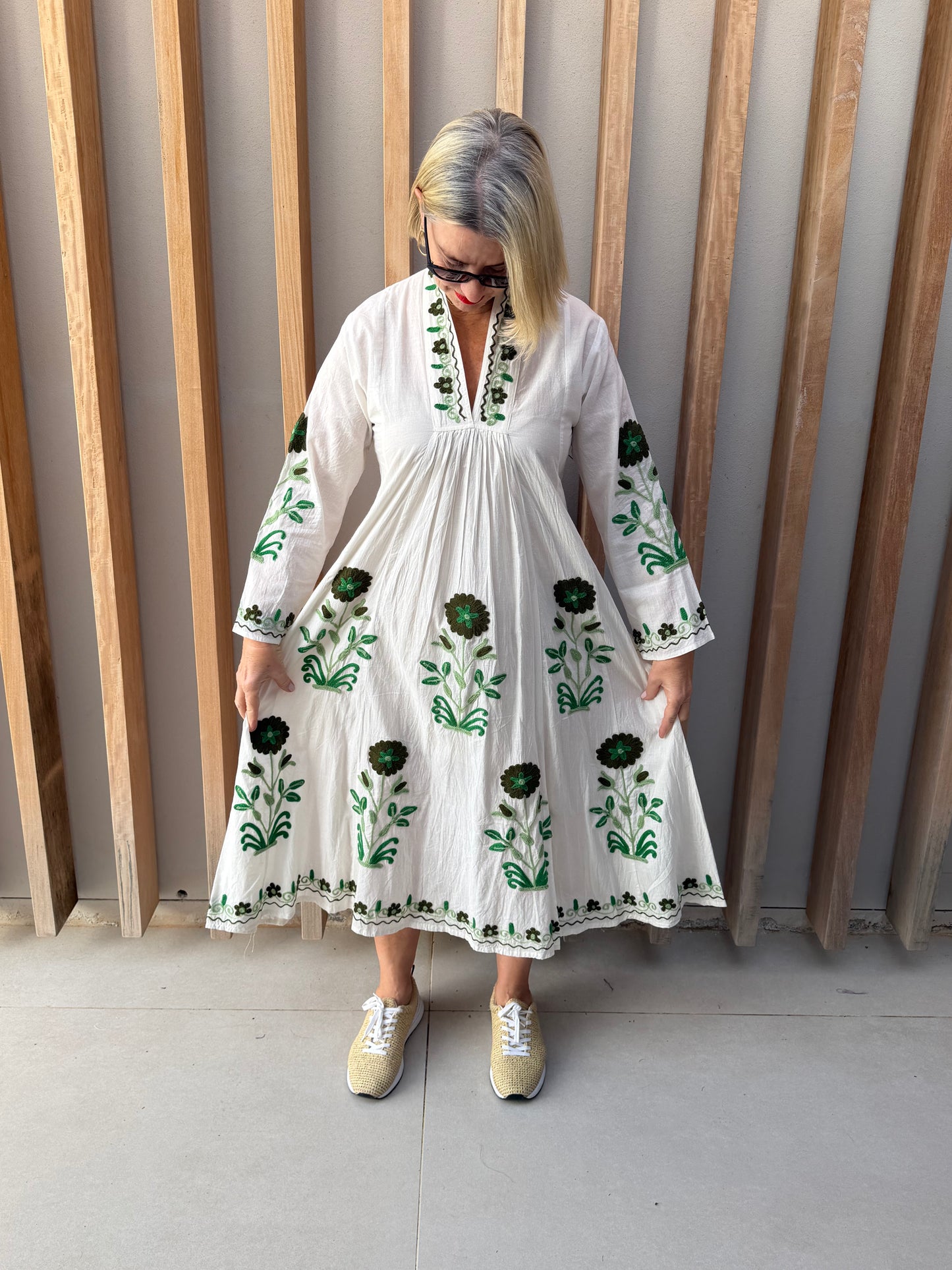 White dress with embroidered green daisy
