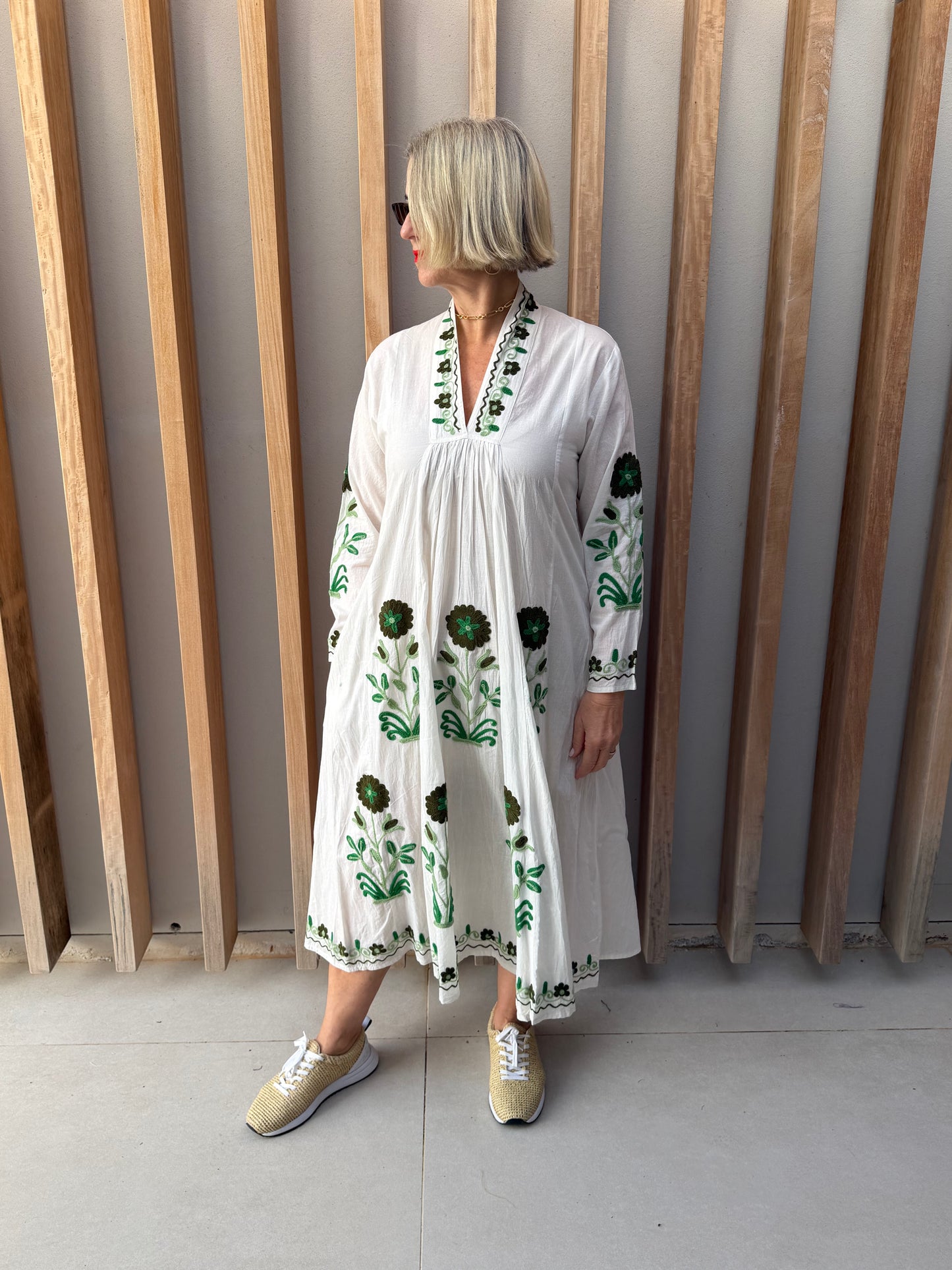 White dress with embroidered green daisy