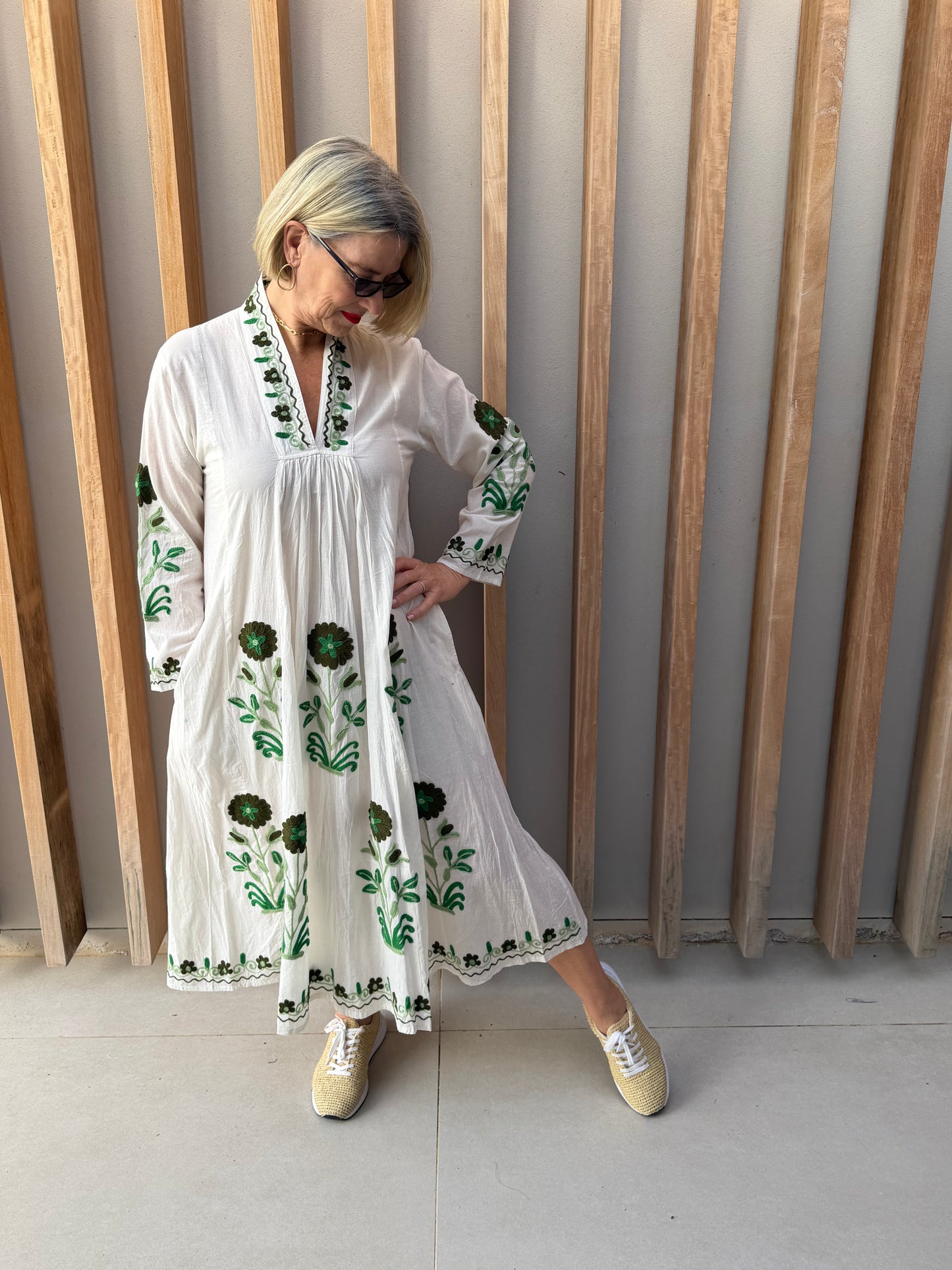 White dress with embroidered green daisy
