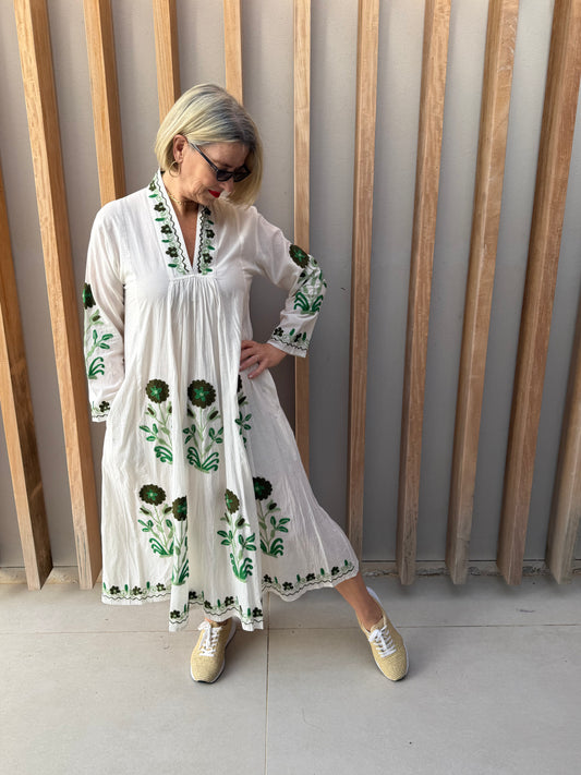 White dress with embroidered green daisy