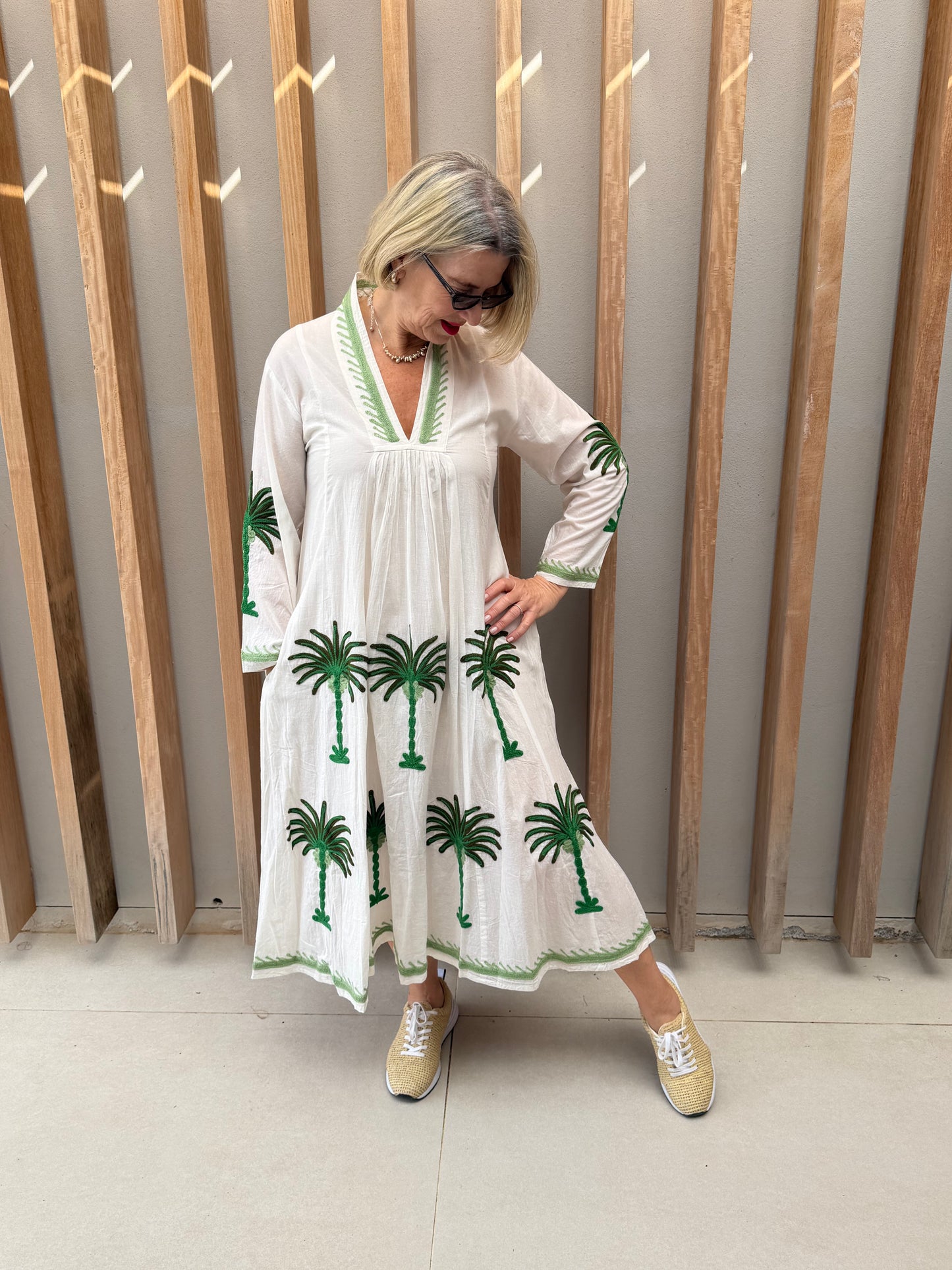 White dress with embroidered green daisies