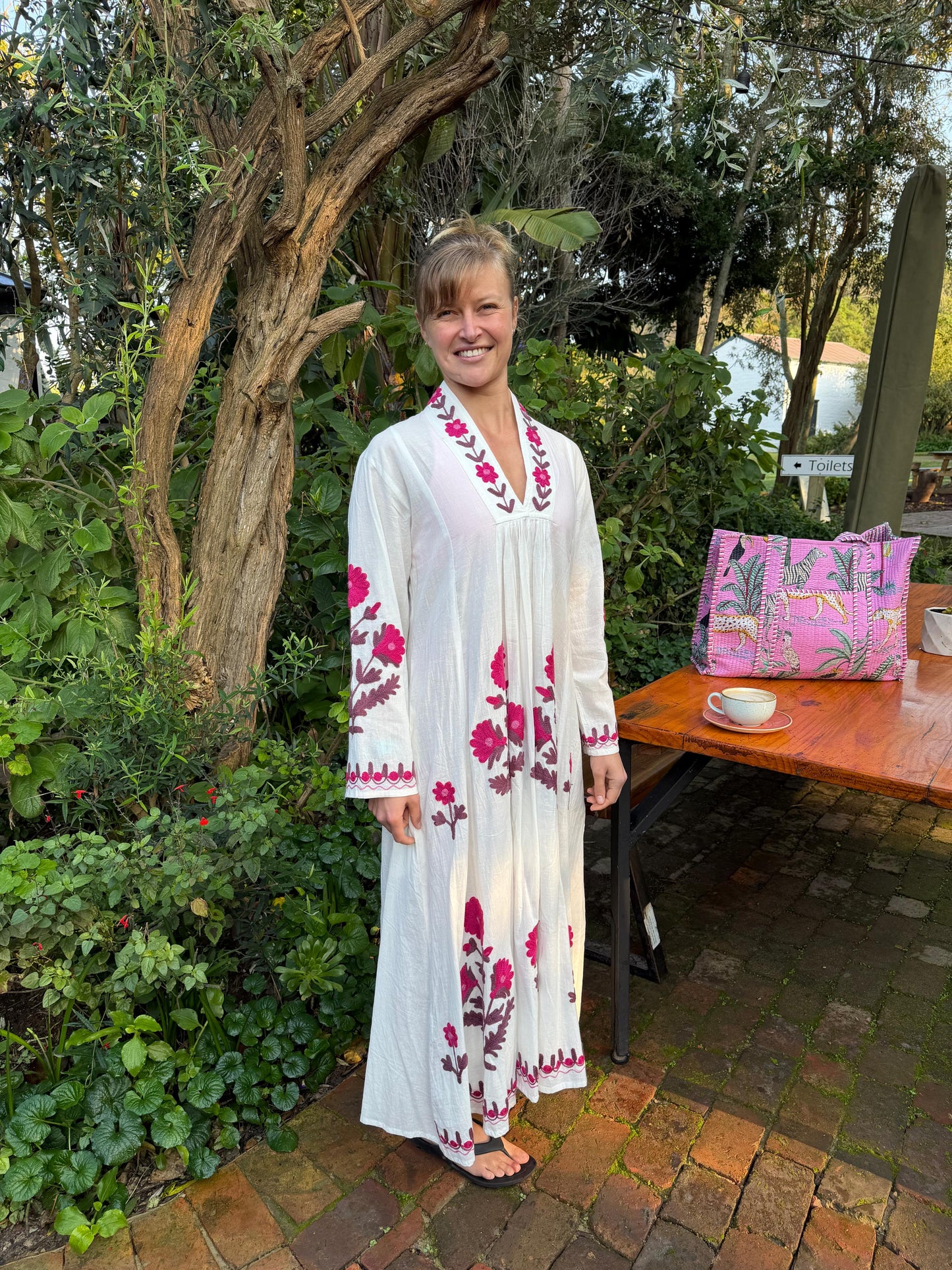 White dress with embroidered Magenta pink daises pattern
