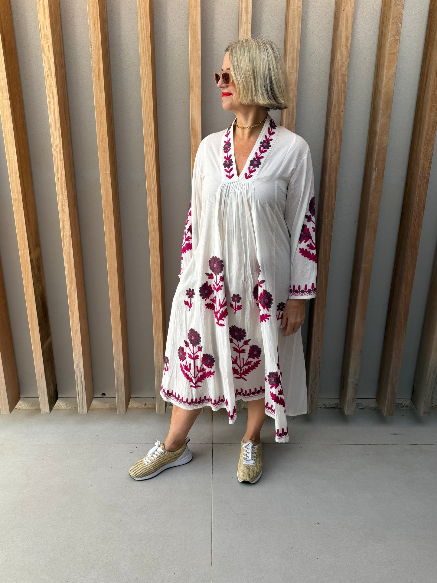 White dress with deep pink embroidered daisies