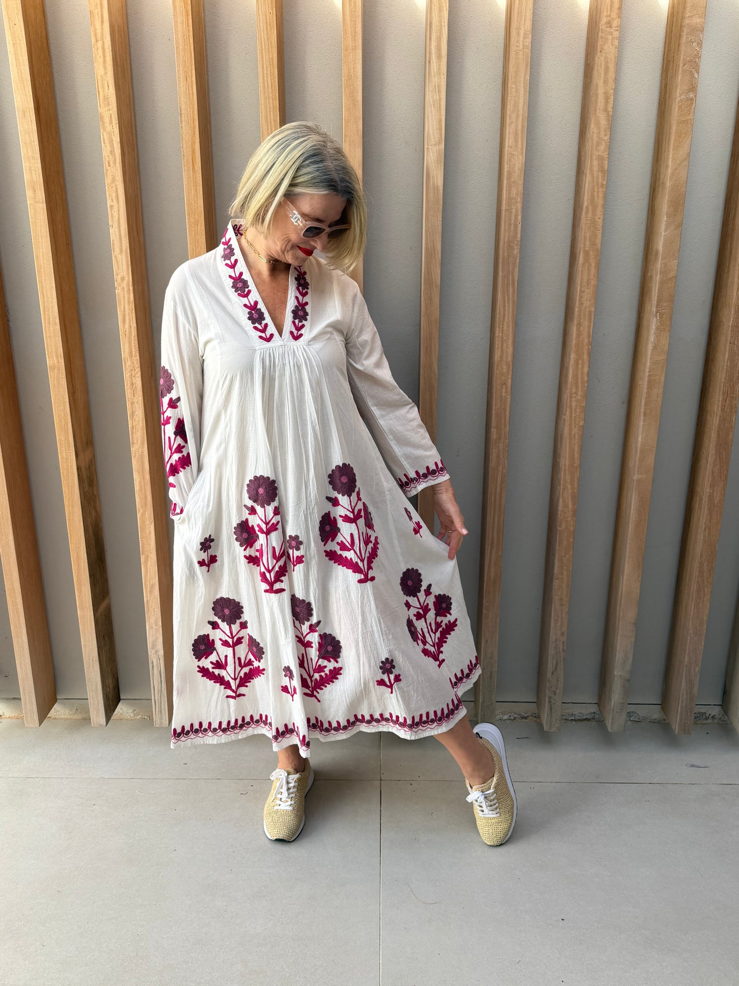 White dress with deep pink embroidered daisies