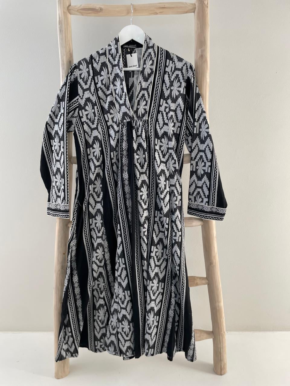 Black dress with white embroidered geometric pattern