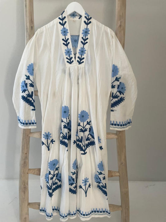 White dress with embroidered light blue daisies