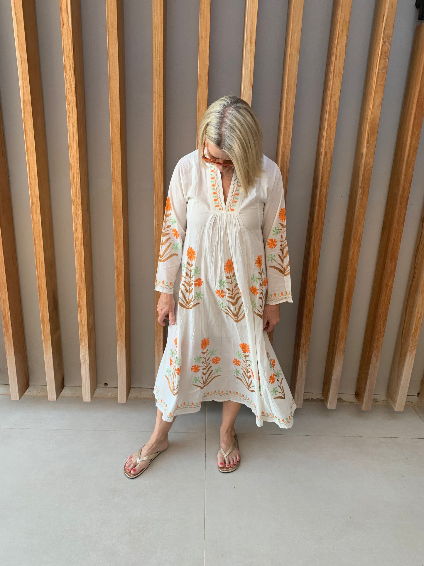 White dress with embroidered Orange & Green floral pattern