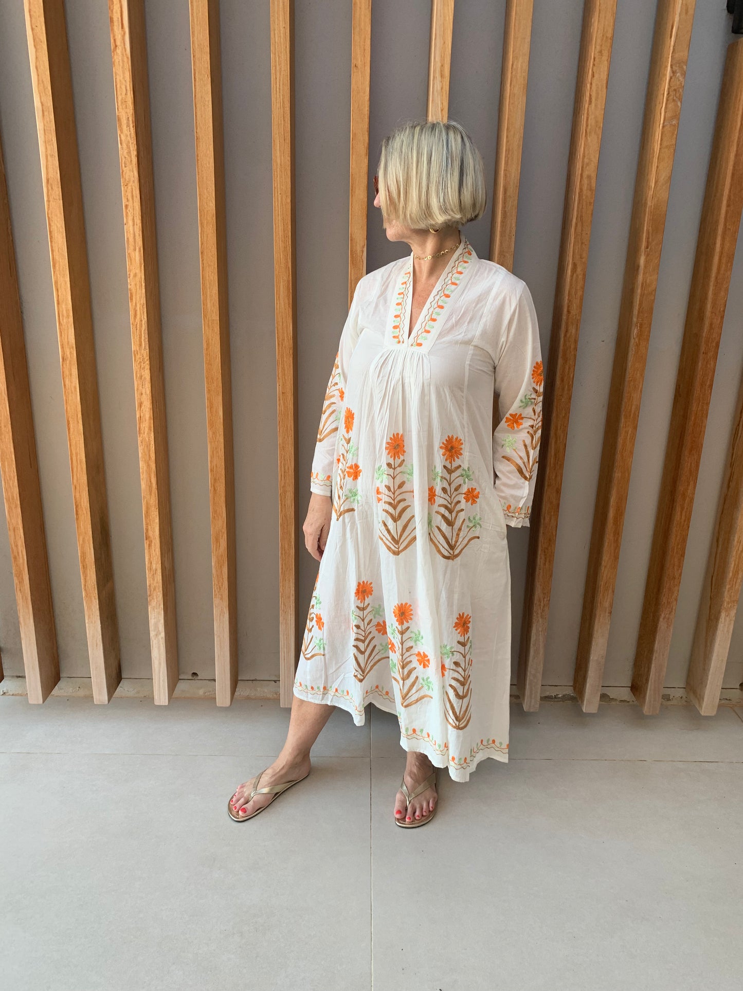 White dress with embroidered Orange & Green floral pattern